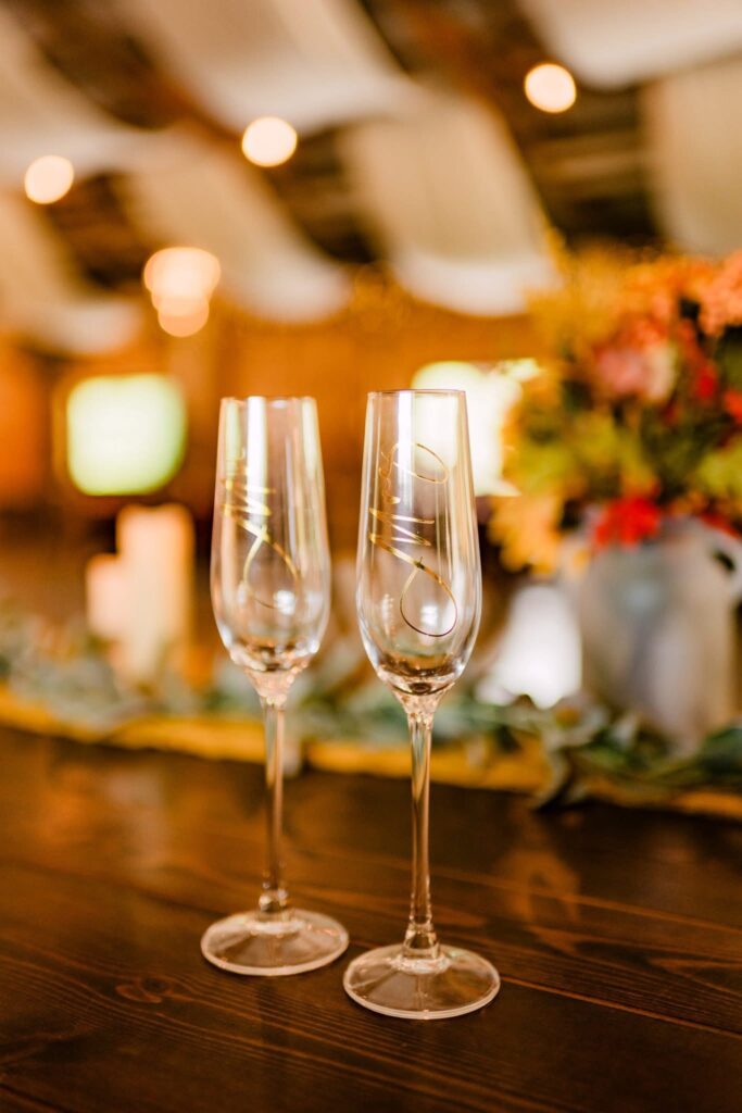Two personalized champagne flutes on a wedding bar