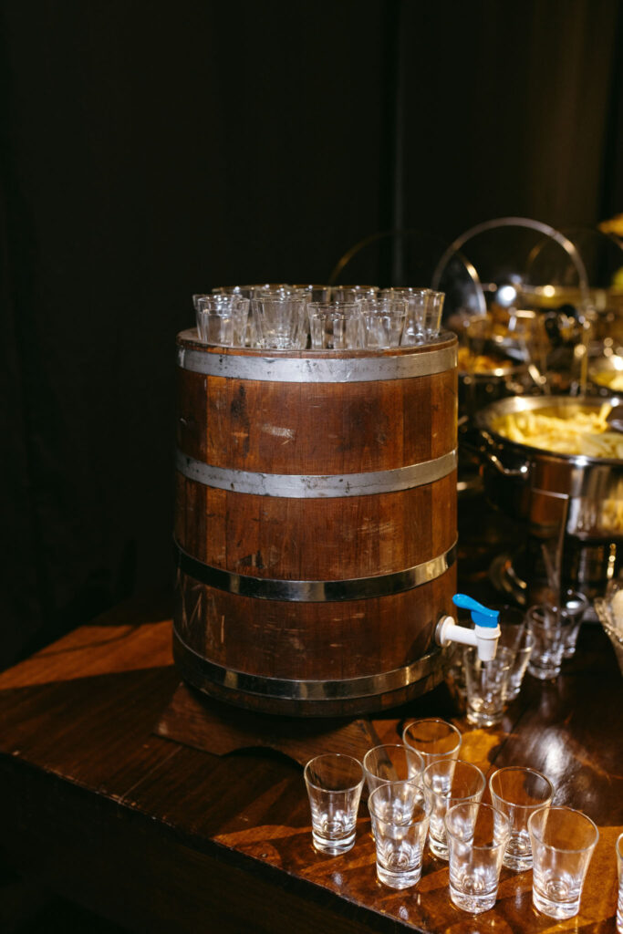 Wooden beverage barrel surrounded by empty shot glasses